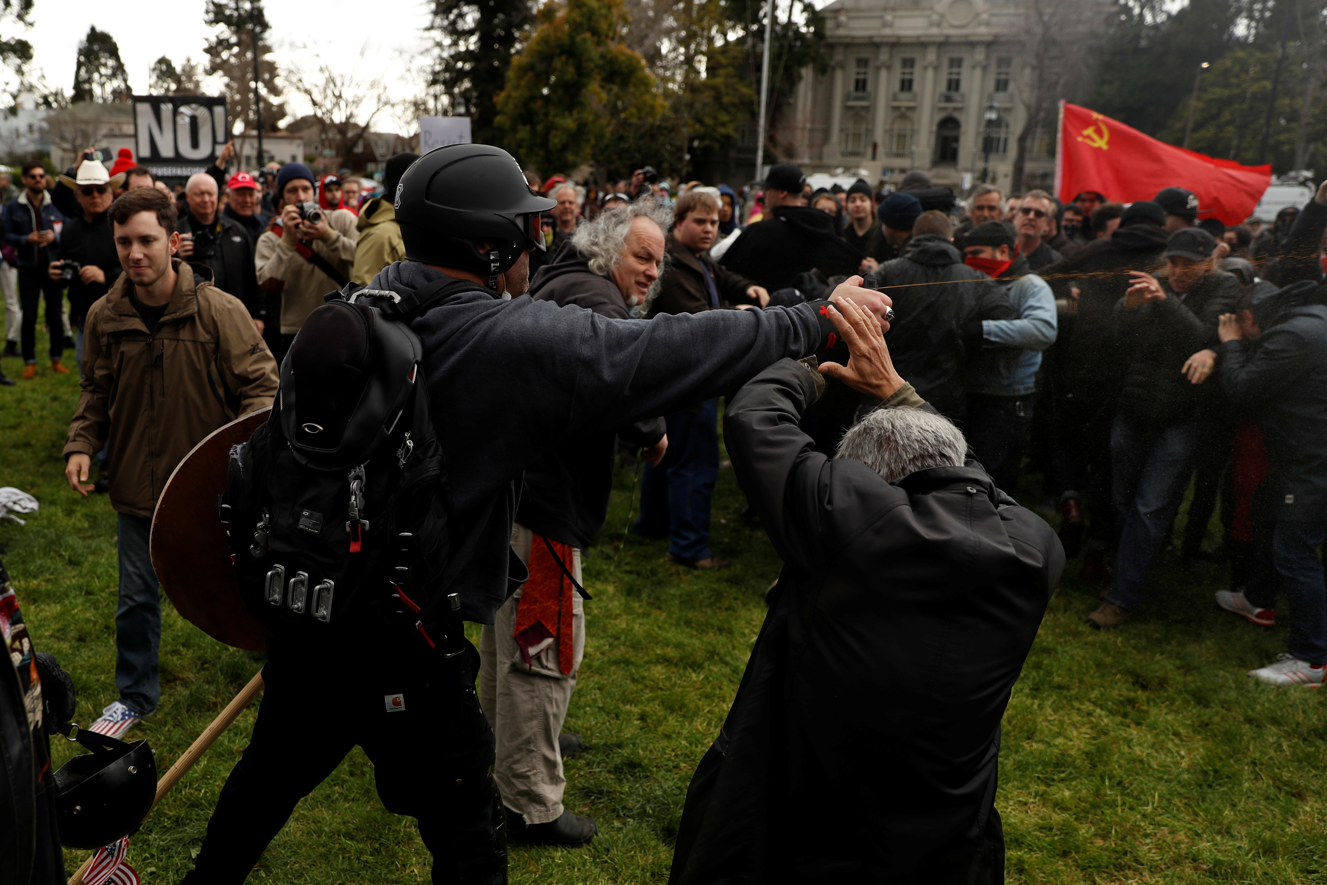 A demonstrator in support of U.S. President Donald Trump sprays pepper spray towards a group of counter-protesters during a "People 4 Trump" rally in Berkeley, California