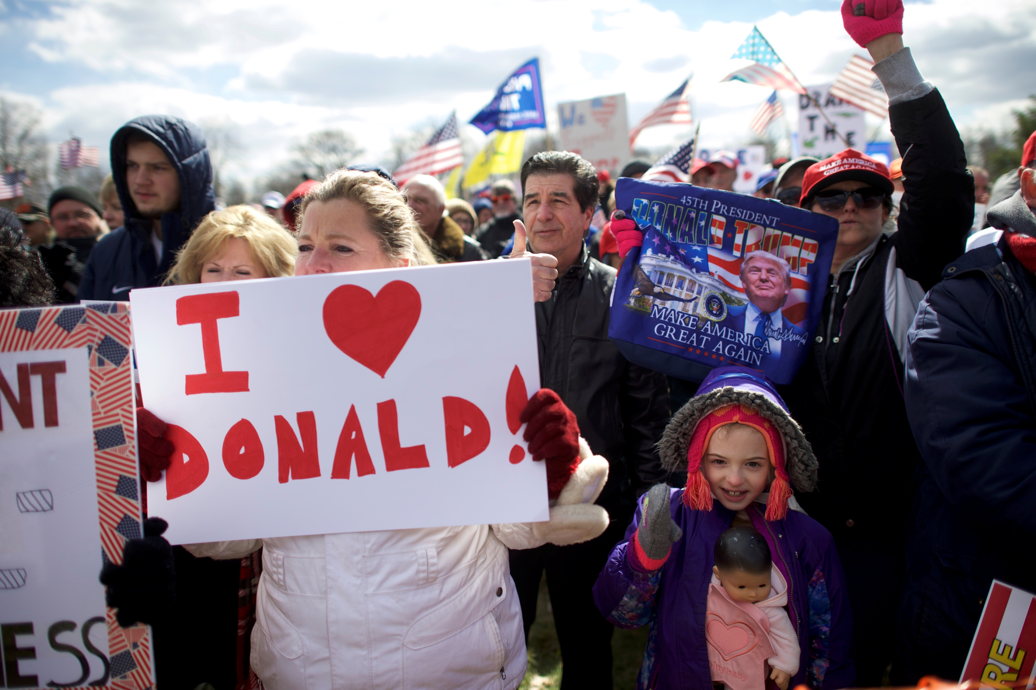 Gia Morris, 8, carries a doll while cheering during a "People 4 Trump" rally at Neshaminy State Park in Bensalem